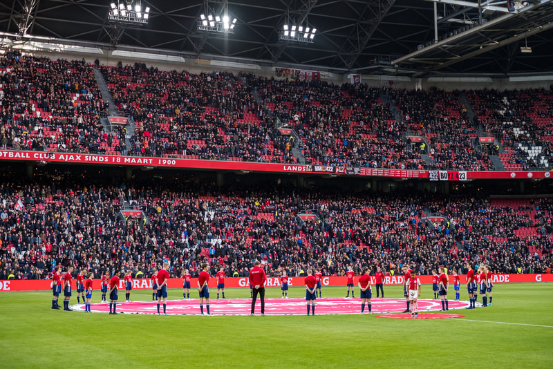 Teams in het veld voor een internationale wedstrijd in een vol stadion